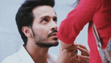 a man with a beard and a woman in a red shirt are looking at each other .