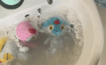 stuffed animals are being washed in a sink with soapy water