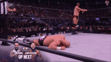 a wrestler is laying on the ground in a wrestling ring with the words up next on the screen