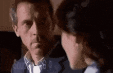 a man and a woman are looking at each other in a room .