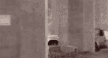 a man is talking on a cell phone behind a wall .