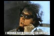 a man wearing sunglasses is talking on a phone with the words i wanna fuck you like an animal written below him