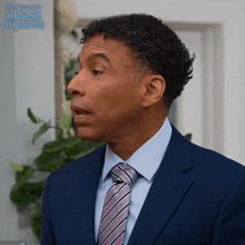 a man in a suit and tie with the words tyler perry 's house of paying behind him