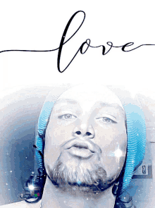 a man with a beard wearing a blue beanie and the word love above him