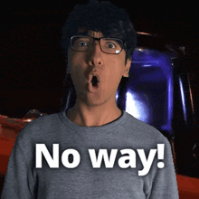 a man wearing glasses says no way in front of a red car
