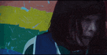 a woman with a rainbow flag behind her