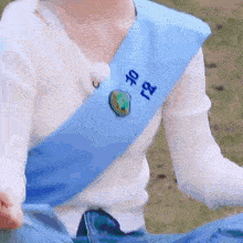 a person wearing a white shirt and a blue sash with the number 18 on it