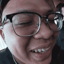 a close up of a man wearing glasses and a hat
