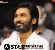 a man with a beard is smiling in front of a star tamil chat advertisement