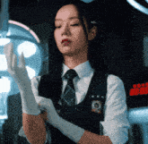 a woman in a school uniform puts on gloves