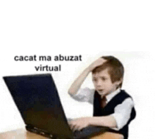 a young boy is sitting at a table using a laptop computer .