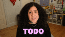 a woman with curly hair says todo in pink