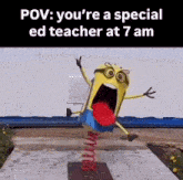 a statue of a minion with a red tongue sticking out is on a spring in front of a building .