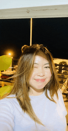 a woman taking a selfie with her eyes closed and smiling
