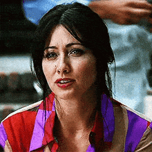 a close up of a woman 's face wearing a striped shirt .