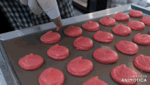 a tray of pink cookies with the words made in animotica on the bottom