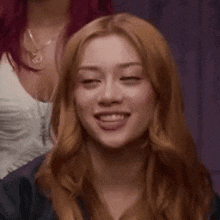 a woman with red hair is smiling with her eyes closed and her mouth open .