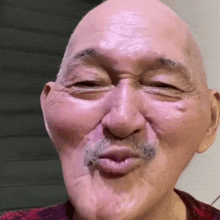 an older man with a mustache is making a funny face .