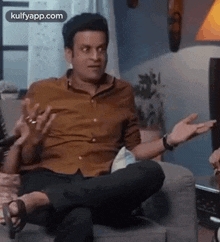 a man is sitting on a couch with his feet up and making a funny face .