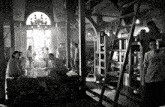 a black and white photo of a group of people in a room with bunk beds