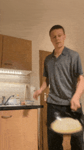 a man in a striped shirt is holding a pan in his hand
