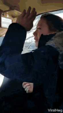a woman is sitting in a car with her hands in the air