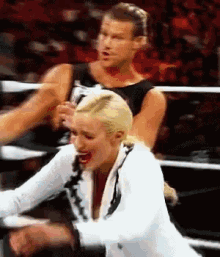 a man and woman are wrestling in a ring and the woman is screaming