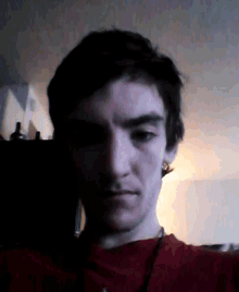 a close up of a man 's face with a red shirt on