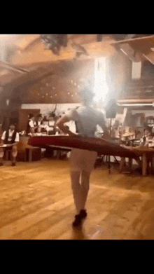 a man is dancing on a wooden floor in front of a crowd of people .