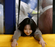 a woman is laying on her stomach on a yellow cushion