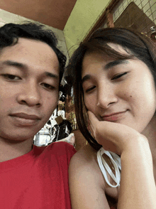 a man and a woman are posing for a picture with the woman resting her head on the man 's shoulder