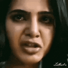 a close up of a woman 's face with a very angry look on her face .