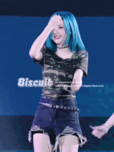 a woman with blue hair is wearing a camouflage shirt and shorts