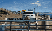 a person sits on a bench that says babyama on it