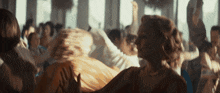 a woman is dancing in a crowded room
