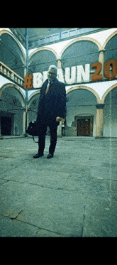 a man stands in front of a large sign that says braun20