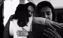 a man and a woman hugging each other in a black and white photo