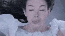 a close up of a woman making a funny face with her eyes closed