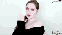 a woman wearing a black sweater and red eye shadow is making a funny face .