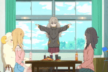 a girl stands in front of a window with her arms outstretched and a bottle of orange juice in front of her