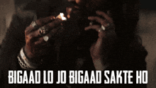 a man lighting a cigarette with the words " bigaad lo jo bigaad sakte ho " on the bottom