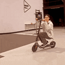 a man is riding a scooter in front of a sign that says " when all "