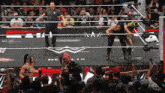 a referee stands in the middle of a wrestling ring with a sign that says nelix on it