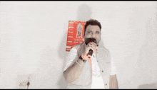 a man in a white shirt is standing in front of a sign that says ' coca cola '