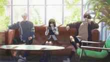 three anime characters are sitting on a couch with a girl playing a game