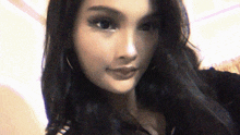 a close up of a woman 's face with long black hair and hoop earrings