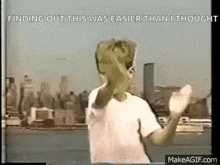 a young boy is dancing in front of a city skyline in a video .