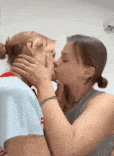 two women are kissing each other in front of a white background .