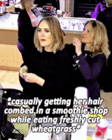 a woman is getting her hair cut in a smoothie shop while eating freshly cut wheatgrass