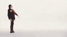 a man in a suit and tie is walking across a white surface